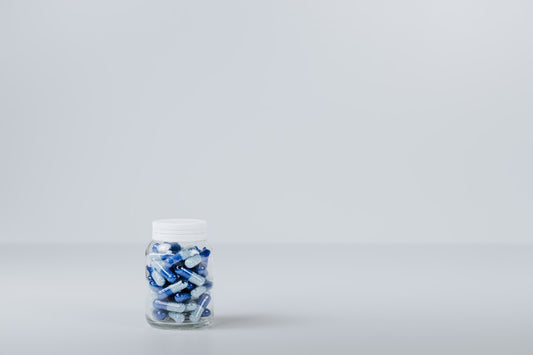 Rows of supplement capsules and bottles on a clean white surface