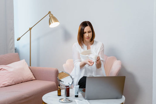 An adult researching personal-care decisions on a laptop at home