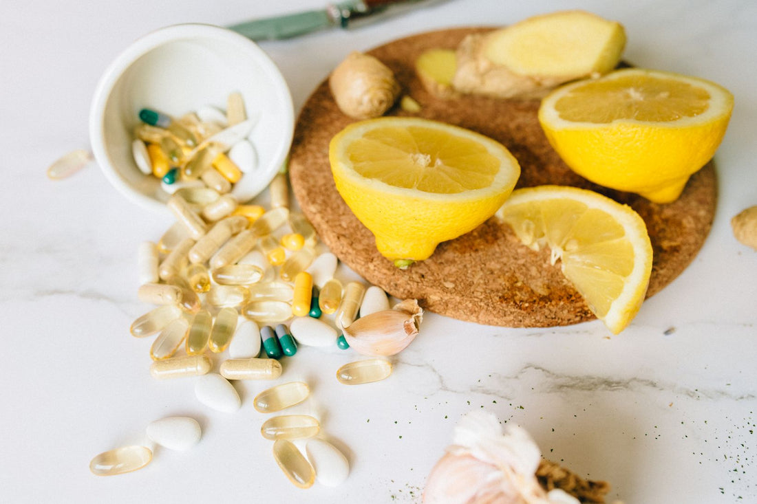 Supplement capsules beside fresh citrus fruit on a light table
